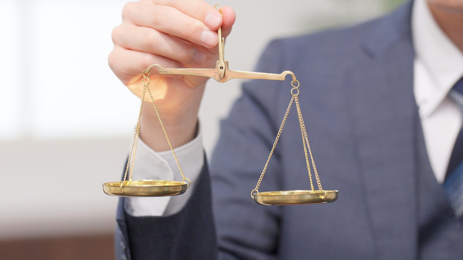 Hands of a businessman holding a scale